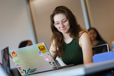 A female student works on a laptop during class
